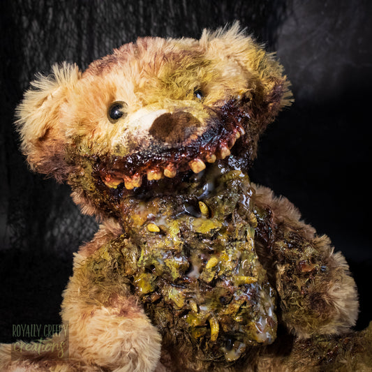 Close up of A horror-themed plush teddy bear with a grotesque, decayed mouth and exposed vomit set against a dark textured background. A 'Royally Creepy Creations' watermark is visible in the bottom corner.