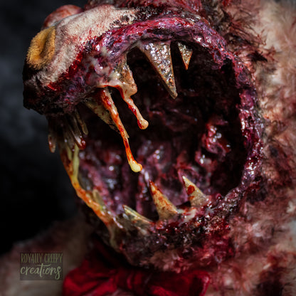 Close-up of creepy teddy bear with sharp teeth and gore details.