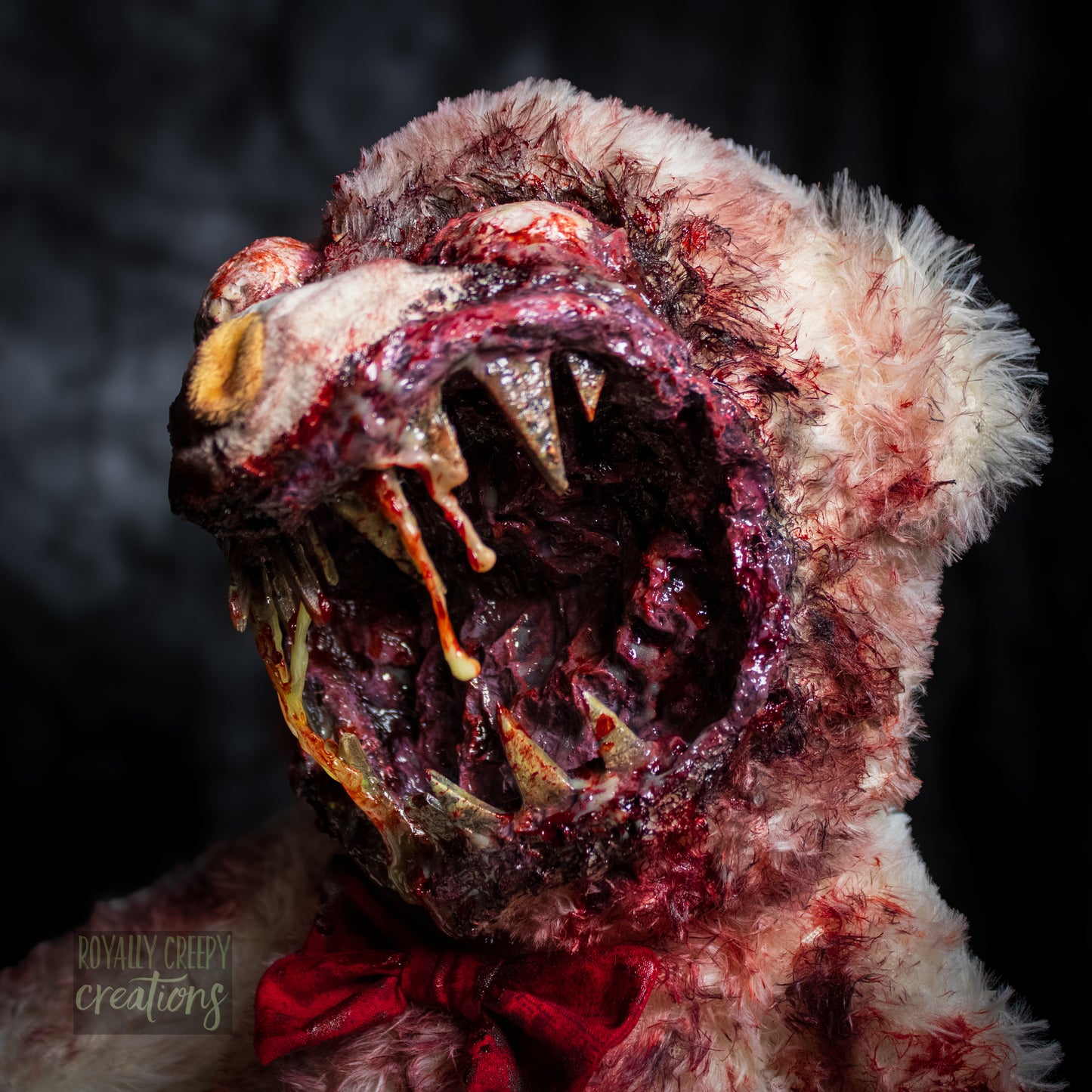 Close-up of creepy teddy bear with sharp teeth and gore details.
