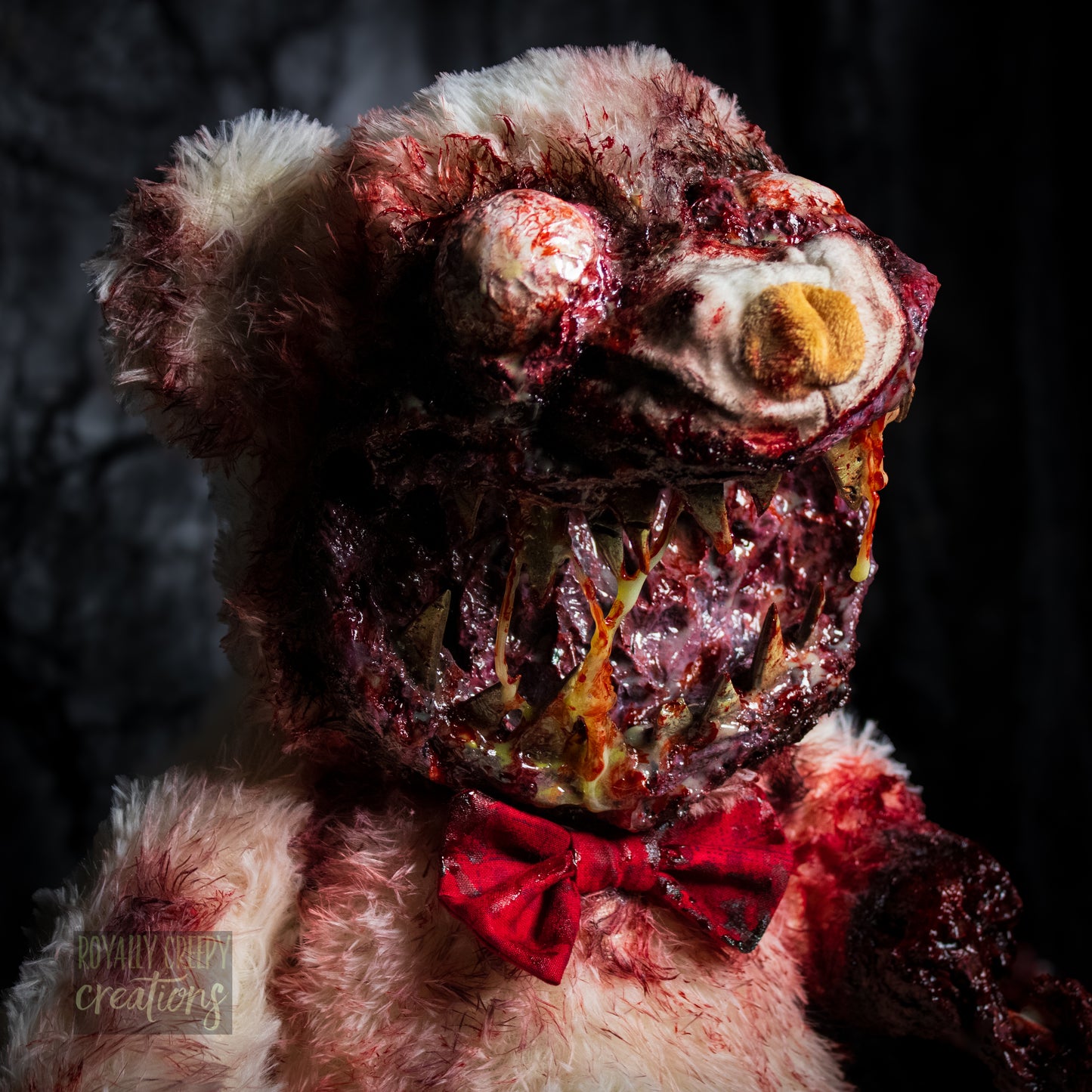 Close-up of creepy teddy bear with sharp teeth and gore details.