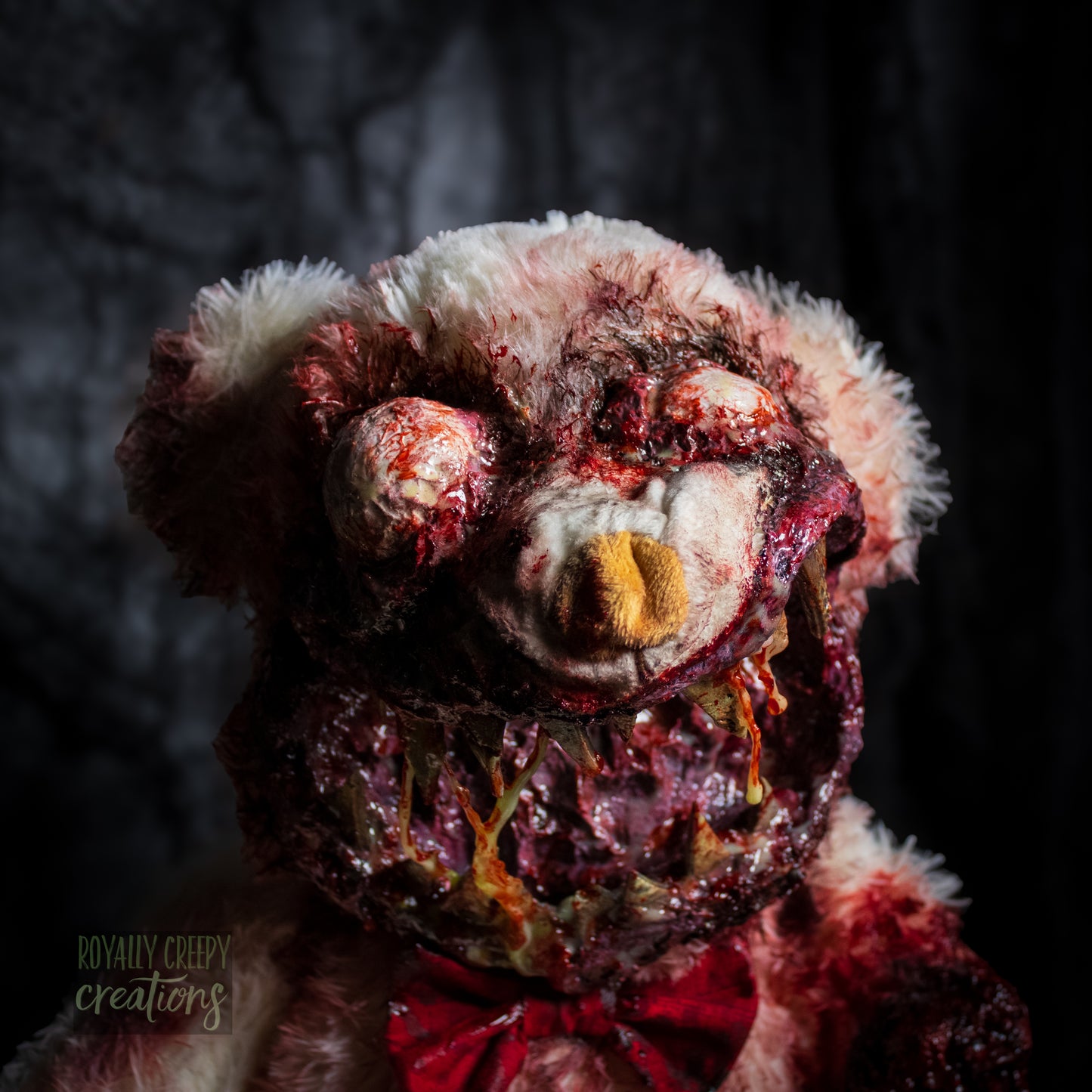 Close-up of creepy teddy bear with sharp teeth and gore details.