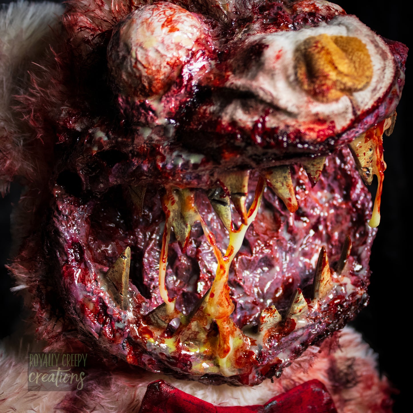 Close-up of creepy teddy bear with sharp teeth and gore details.