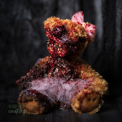 Front view of horror teddy bear with exposed teeth, wearing a tutu & bow.