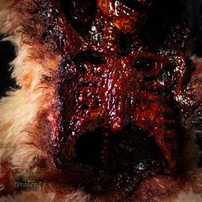 Close-up of middle section of horror themed teddy bear torn open in the front with a gory skeleton emerging from it's body.