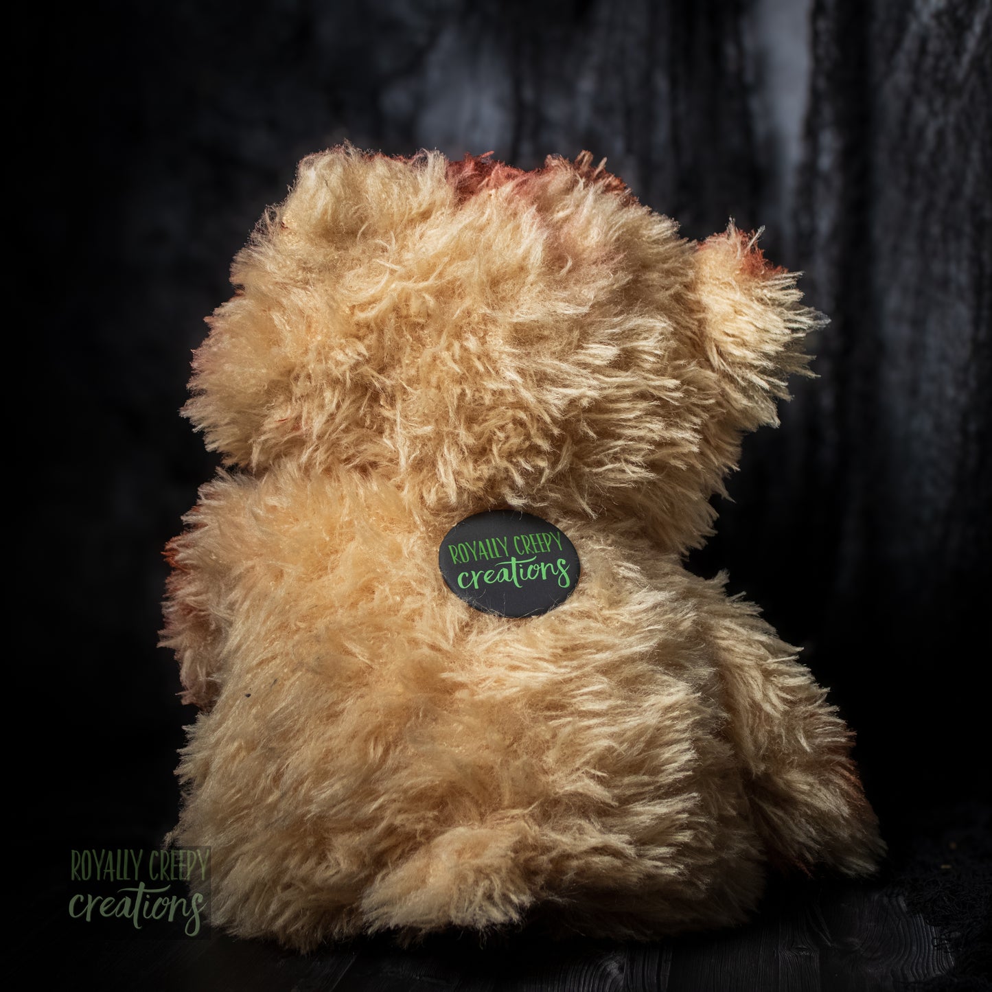 Back of teddy bear with "Royally Creepy Creations" logo.