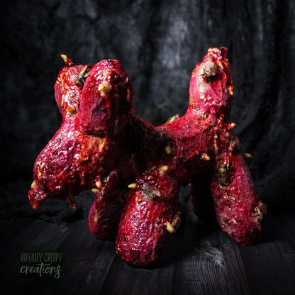 Side of horror version of an infected balloon dog plushie covered in gore, maggots and flies.