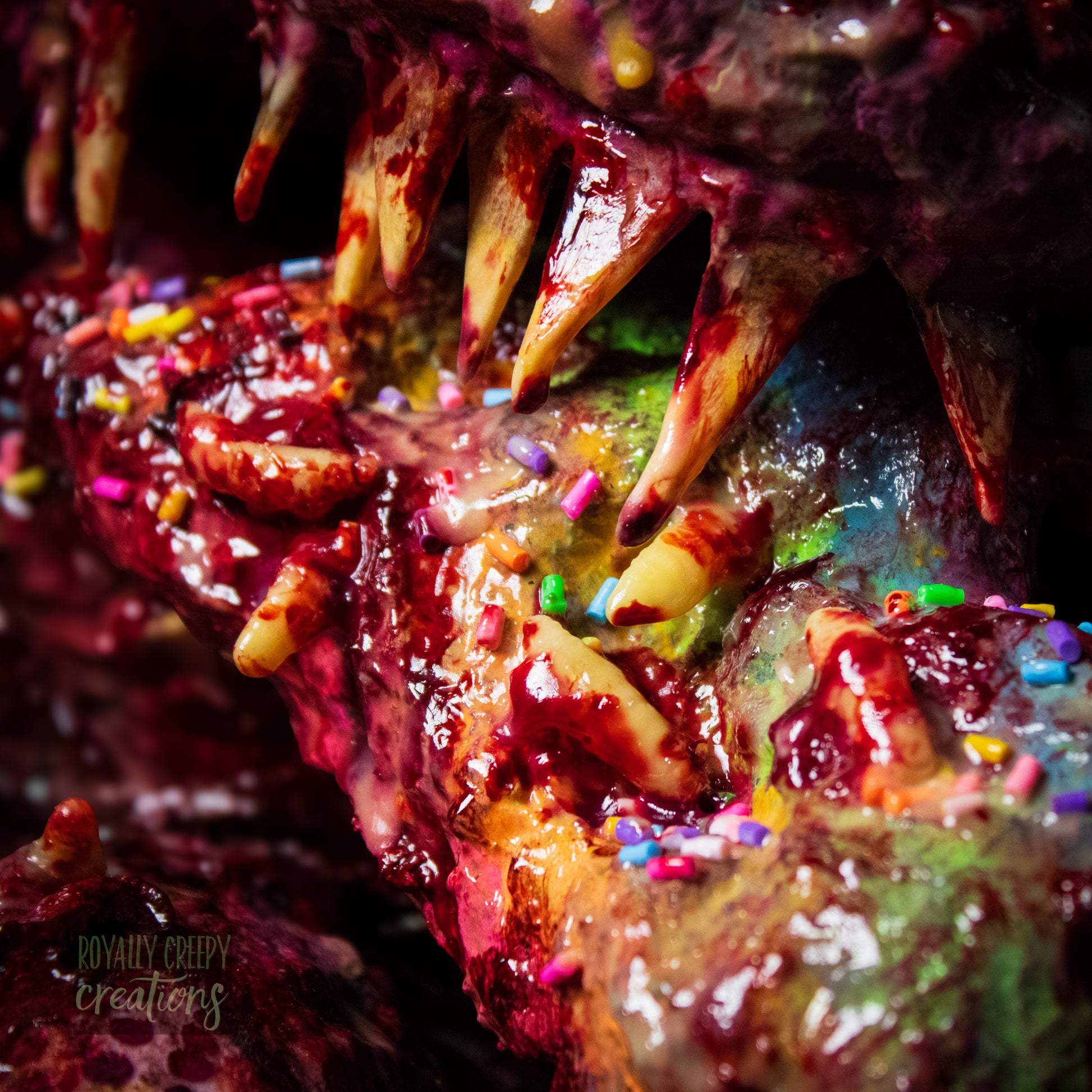 Close-up of top of horror vomit rainbow covered with maggots and colorful sprinkles and fake blood.