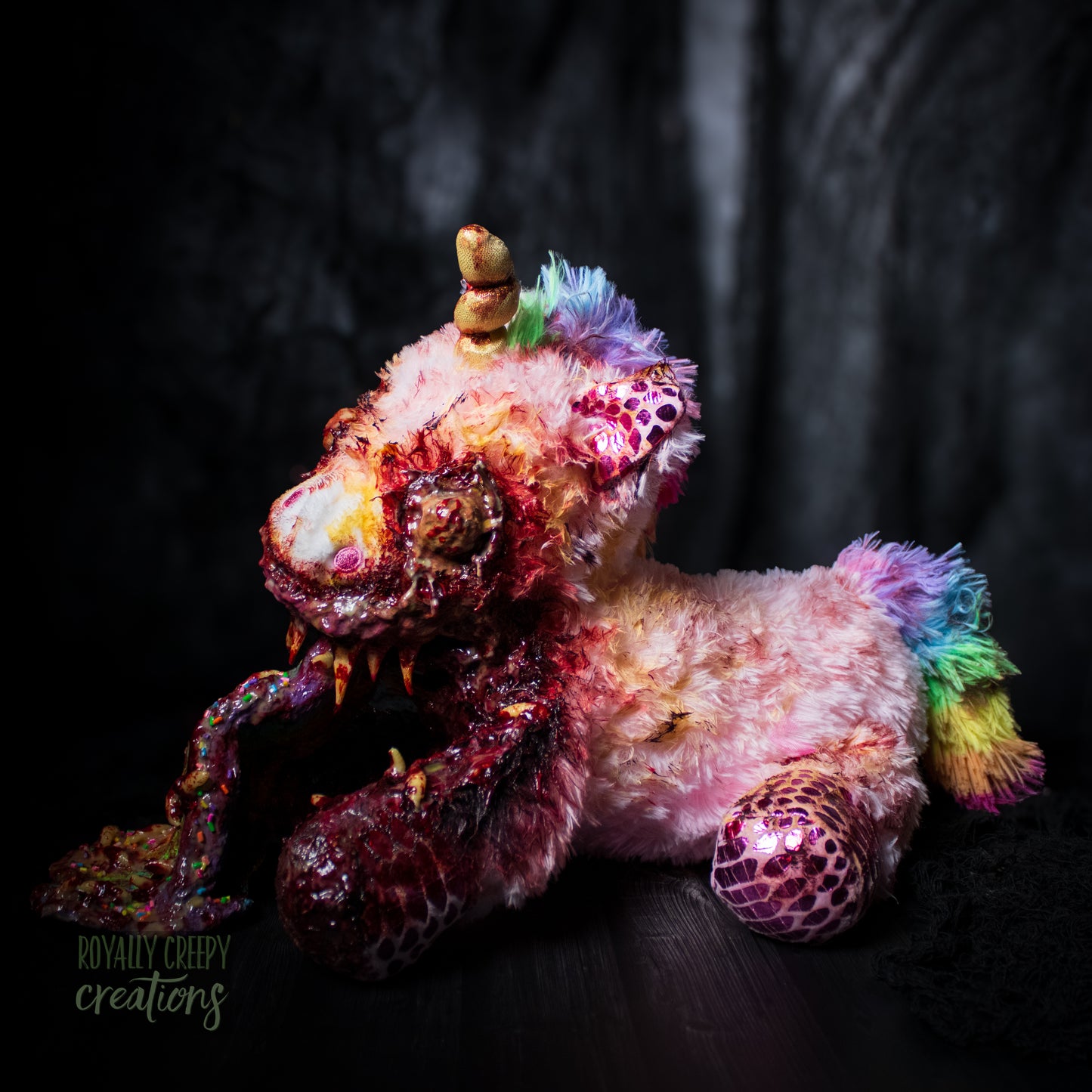 Left side view of horror unicorn plush vomiting a rainbow with a dark background.