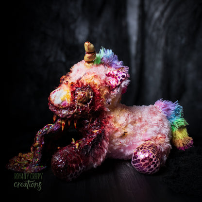 Left side view of horror unicorn plush vomiting a rainbow with a dark background.