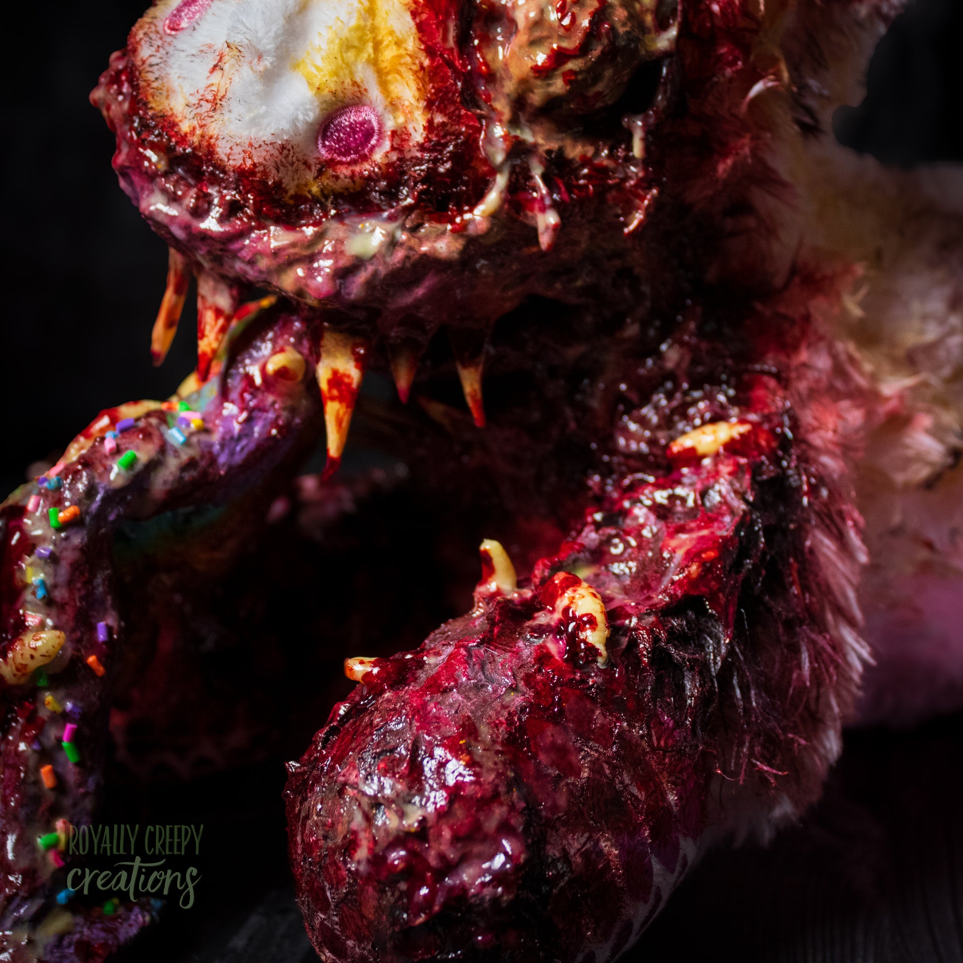 Close-up  of horror unicorn plush arm with maggots with a dark background.