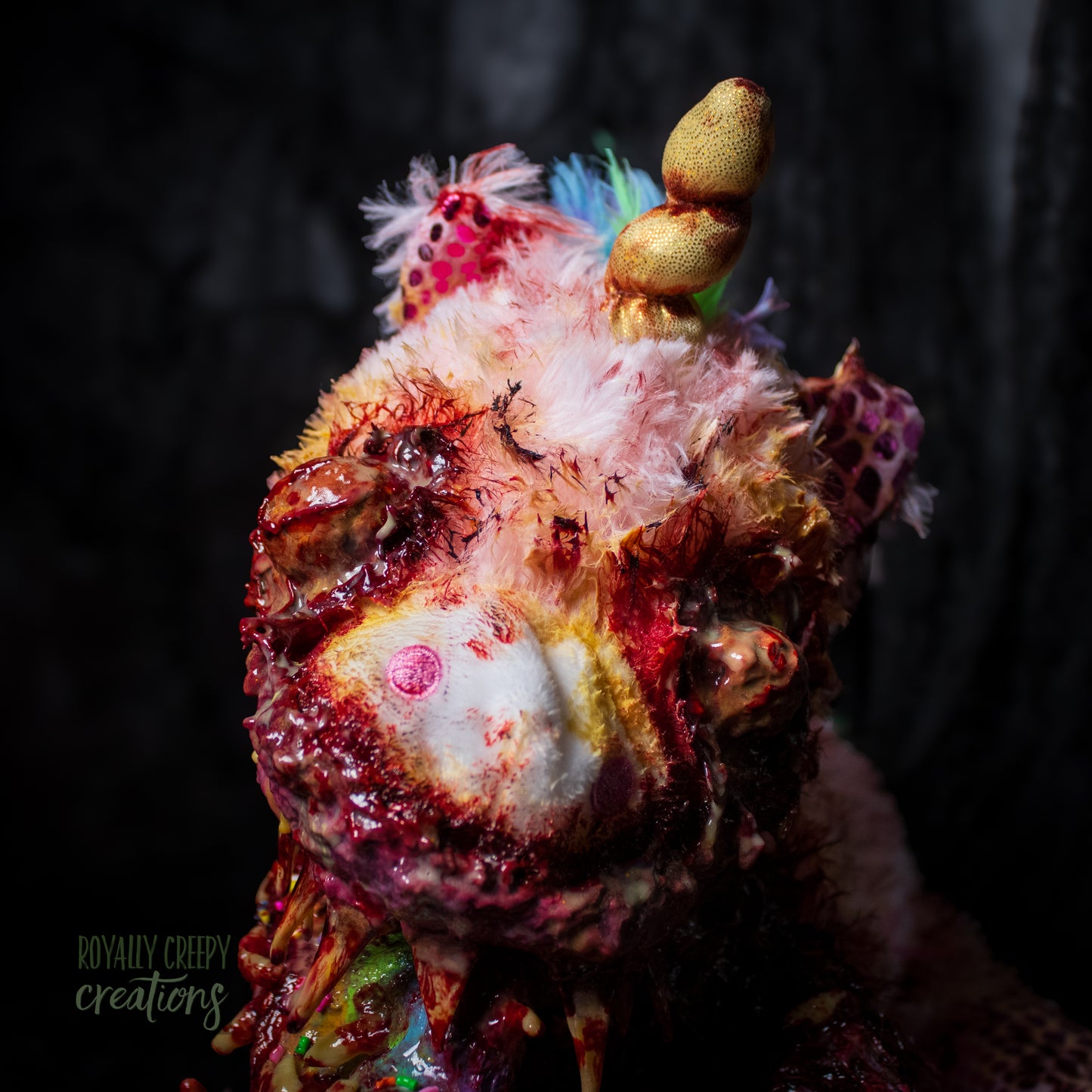 Close-up  of horror unicorn plush face with a dark background.