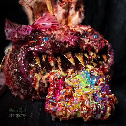 A horror-themed bunny purse featuring a monstrous face with sharp teeth, blue eyes, a pink bow, and a colorful tongue covered in sprinkles, set against a dark background.