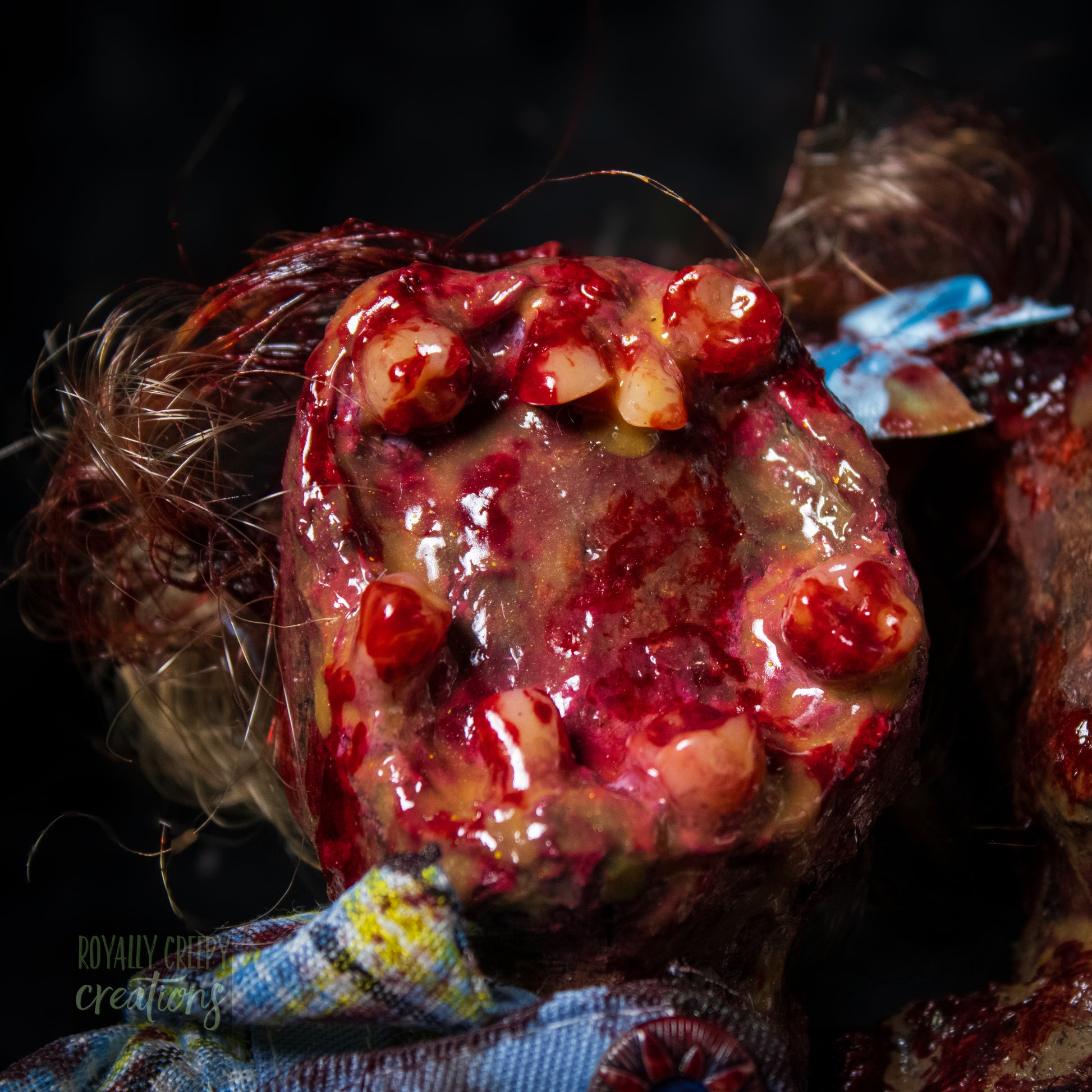 Close-up of male head of conjoined horror doll with a gaping mouth filled with teeth covering entire face.