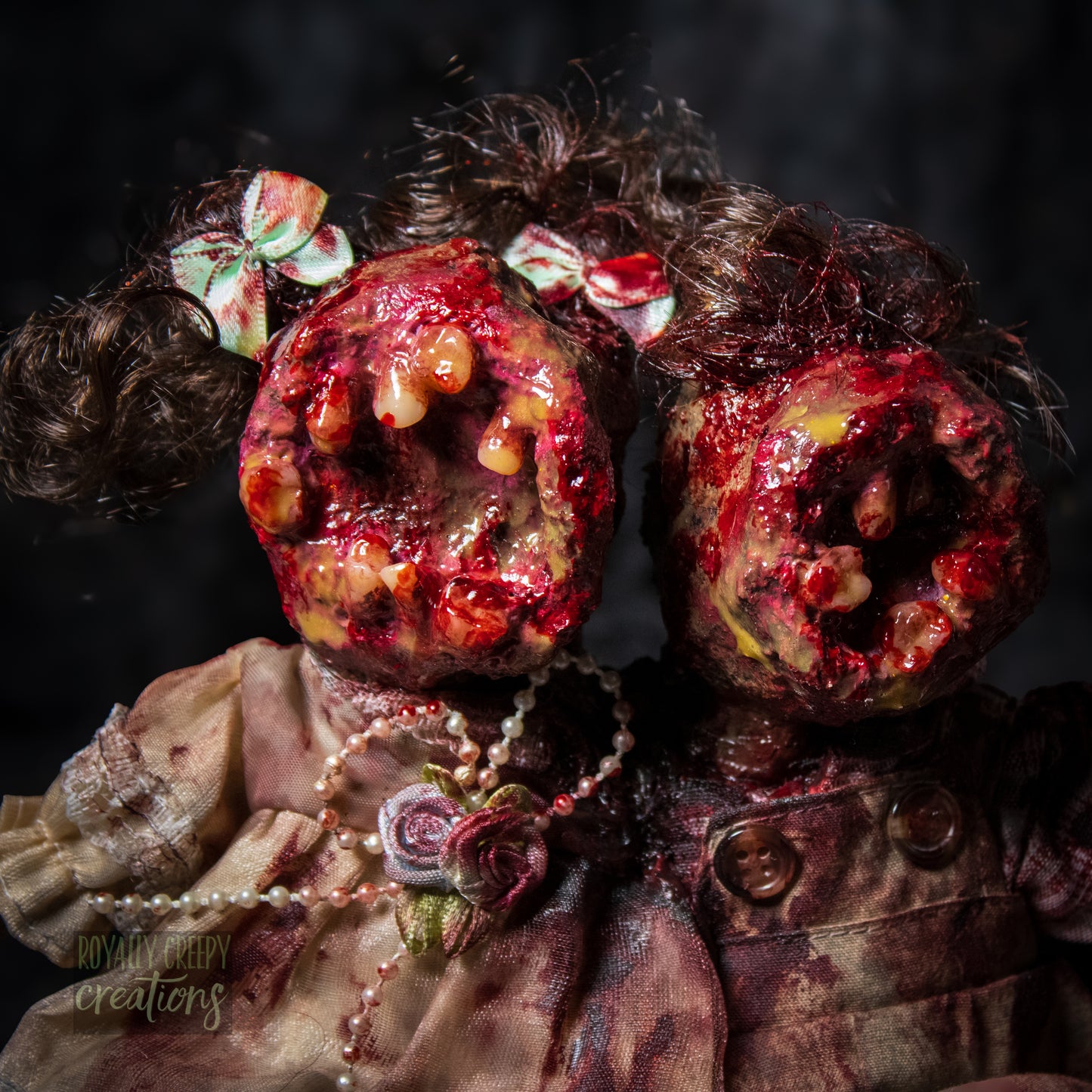 Close-up of conjoined horror doll with a gaping mouth filled with teeth covering both faces.