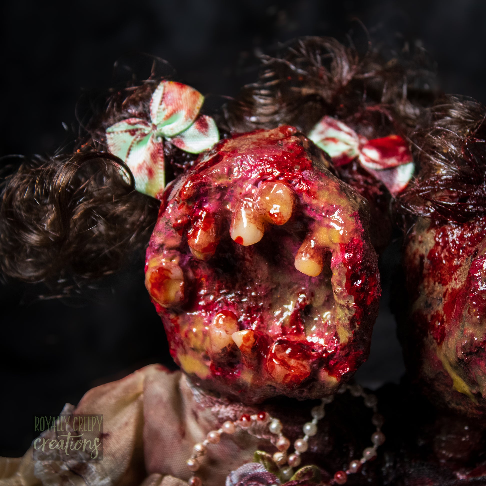 Close-up of female head of conjoined horror doll with a gaping mouth filled with teeth covering entire face.