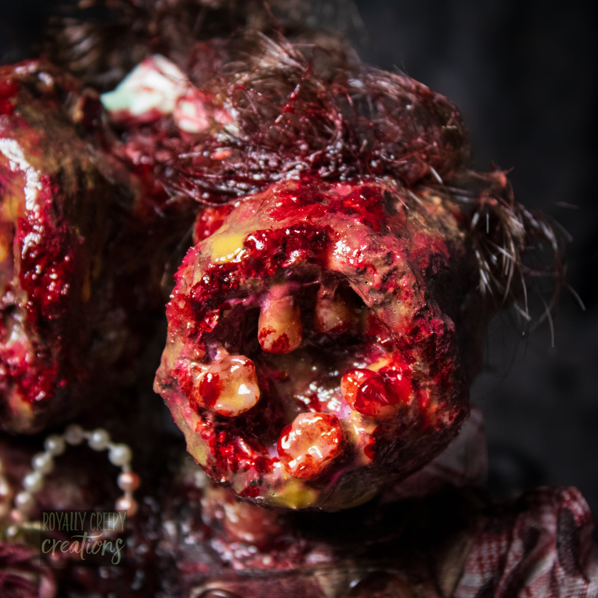 Close-up of male head of conjoined horror doll with a gaping mouth filled with teeth covering entire face.