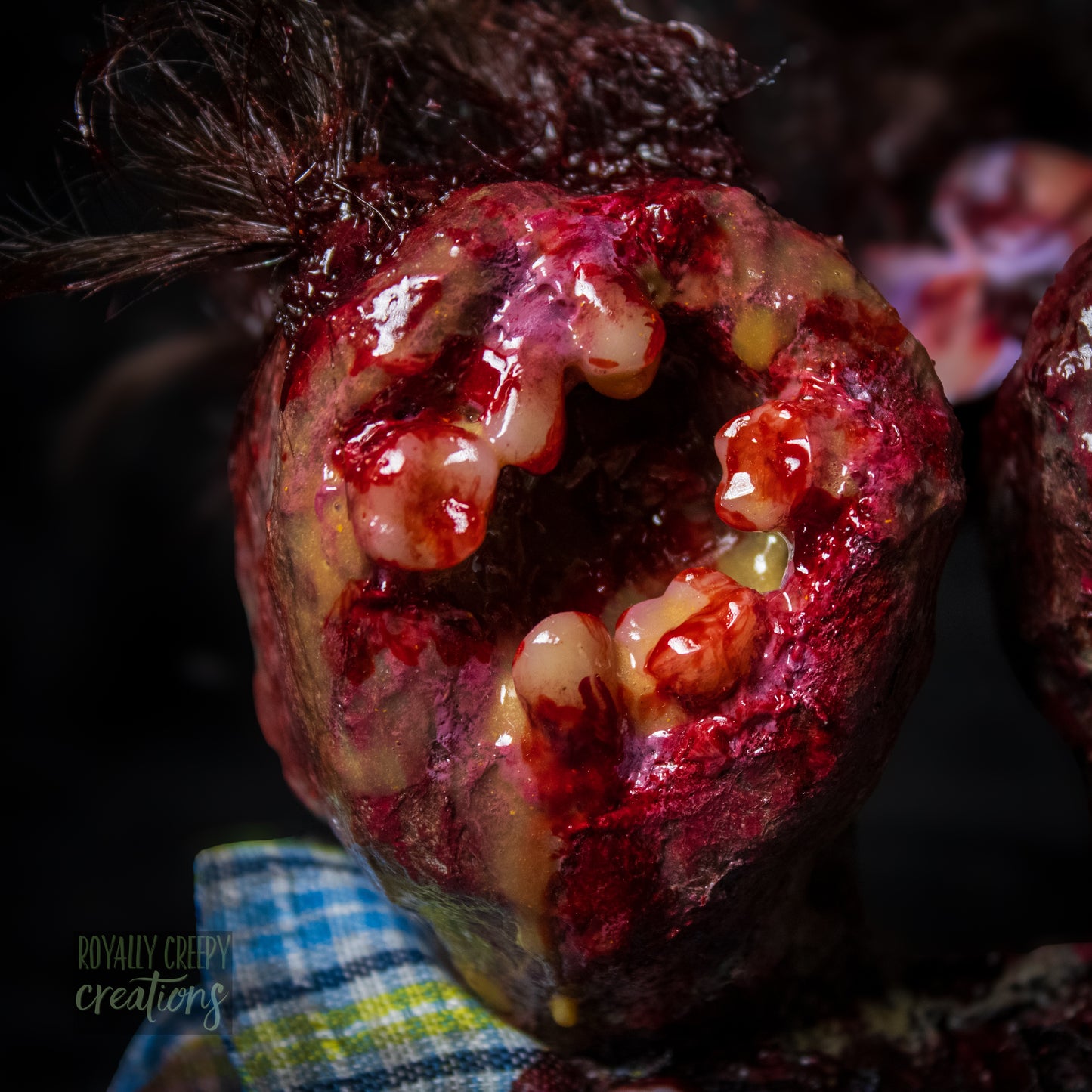 Close-up of male head of conjoined horror doll with a gaping mouth filled with teeth covering entire face.
