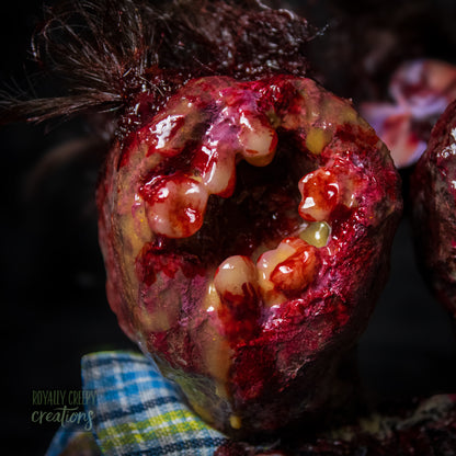 Close-up of male head of conjoined horror doll with a gaping mouth filled with teeth covering entire face.