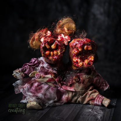 Artistic conjoined horror doll with a gaping mouth filled with teeth covering both faces.