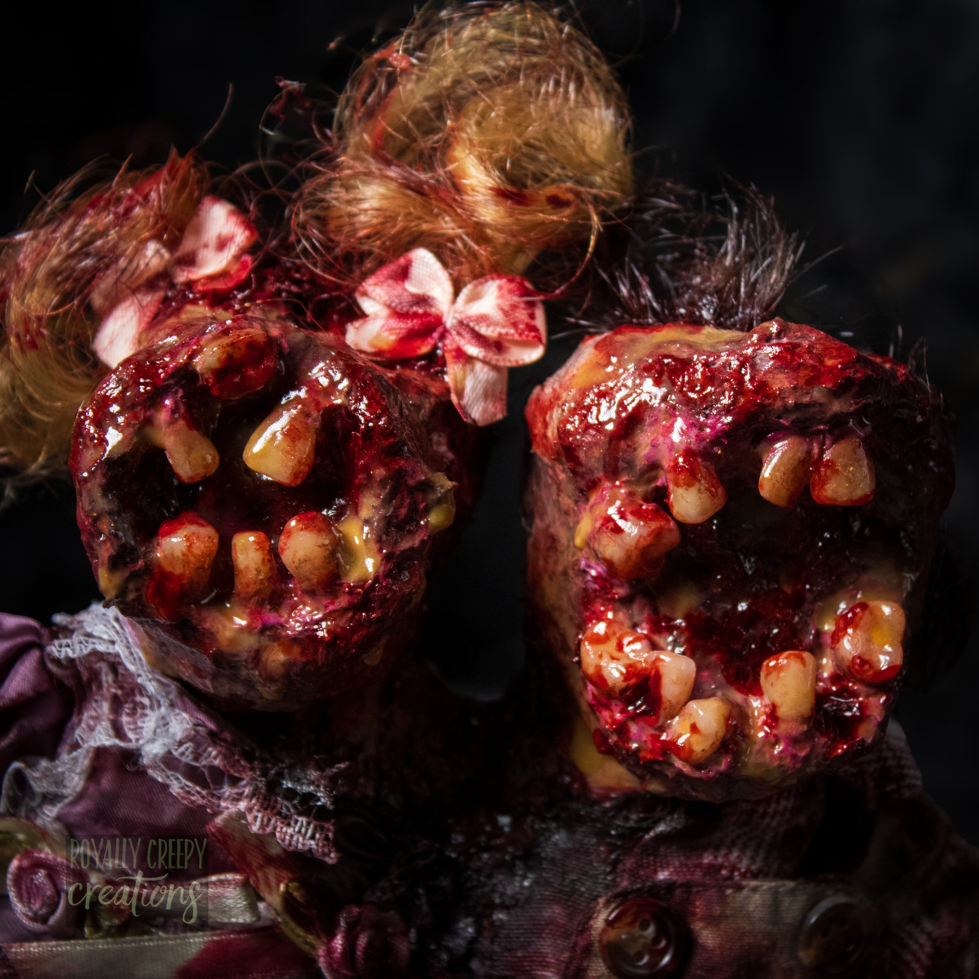 Close-up of conjoined horror doll with a gaping mouth filled with teeth covering both faces.
