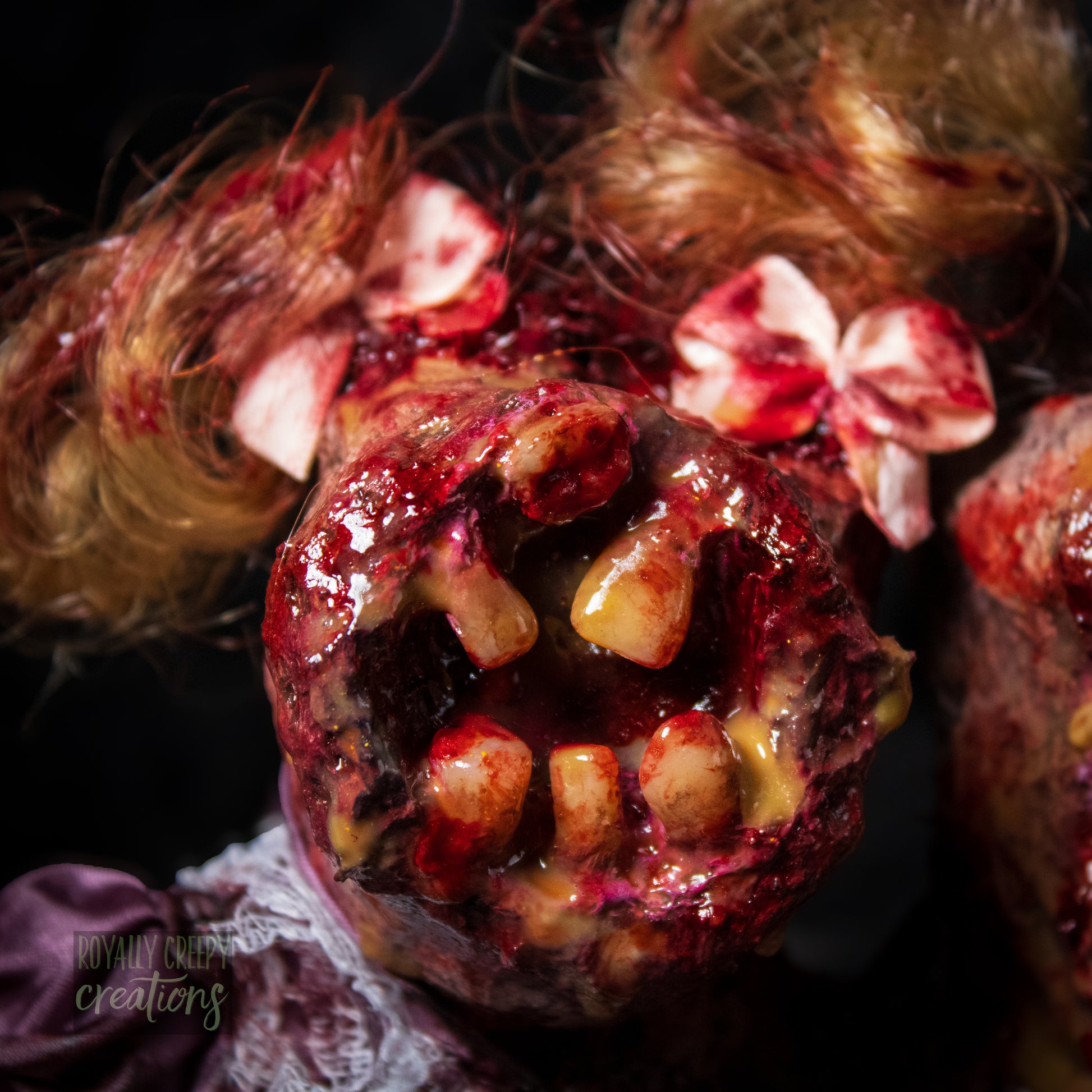 Close-up of female head of conjoined horror doll with a gaping mouth filled with teeth covering entire face.