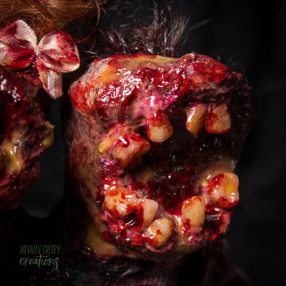 Close-up of male head of conjoined horror doll with a gaping mouth filled with teeth covering entire face.