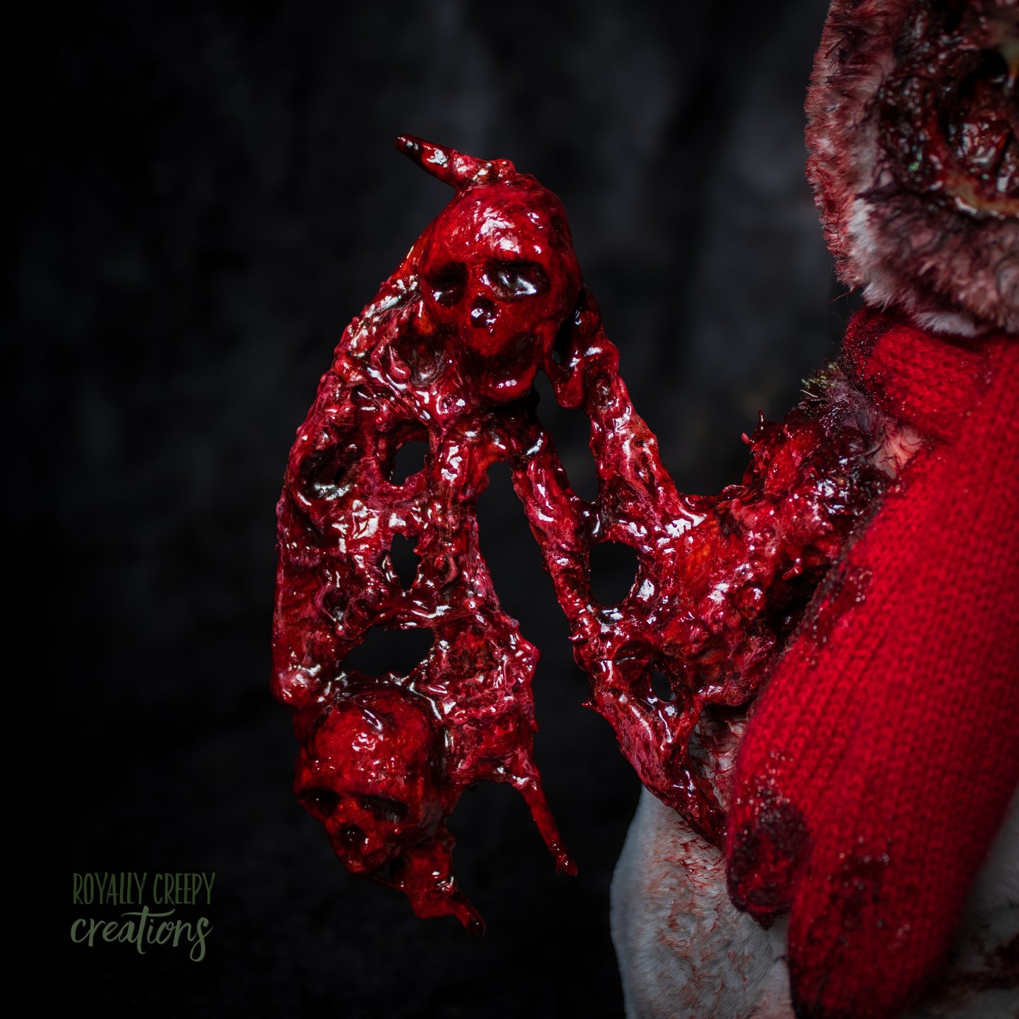 Close-up of a bloody, textured right wing embedded with skulls. 