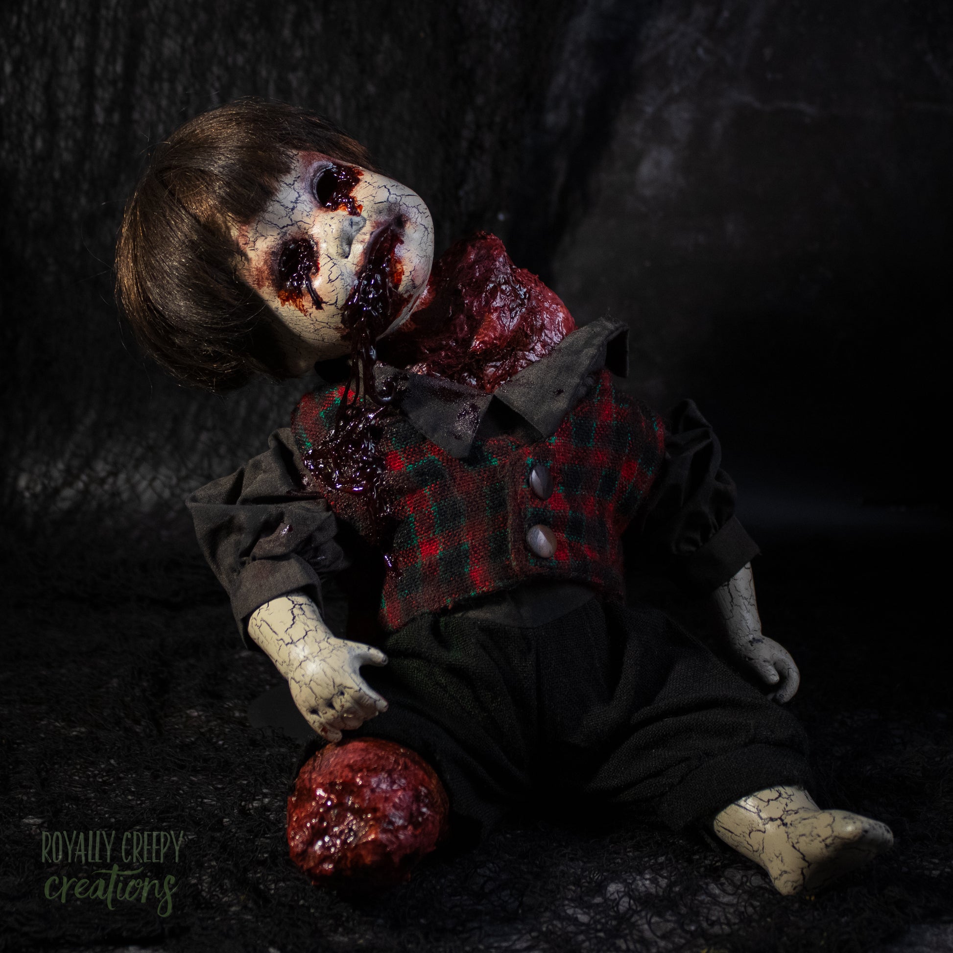 A creepy horror doll with a grotesque bloody wound on the neck, posed on a dark textured background with a severed grotesque leg.