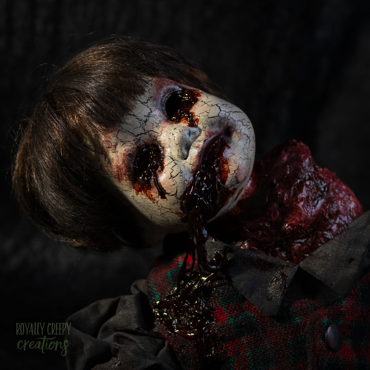 A close-up of a creepy horror doll with a grotesque bloody wound on the neck, posed on a dark textured background.