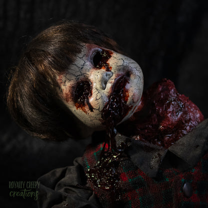 A close-up of a creepy horror doll with a grotesque bloody wound on the neck, posed on a dark textured background.
