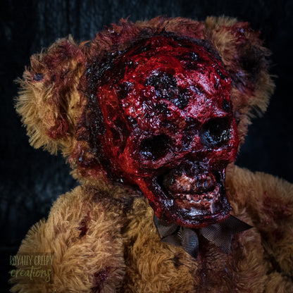 A close-up of a horror teddy bear with an exposed bloody skull for a face.