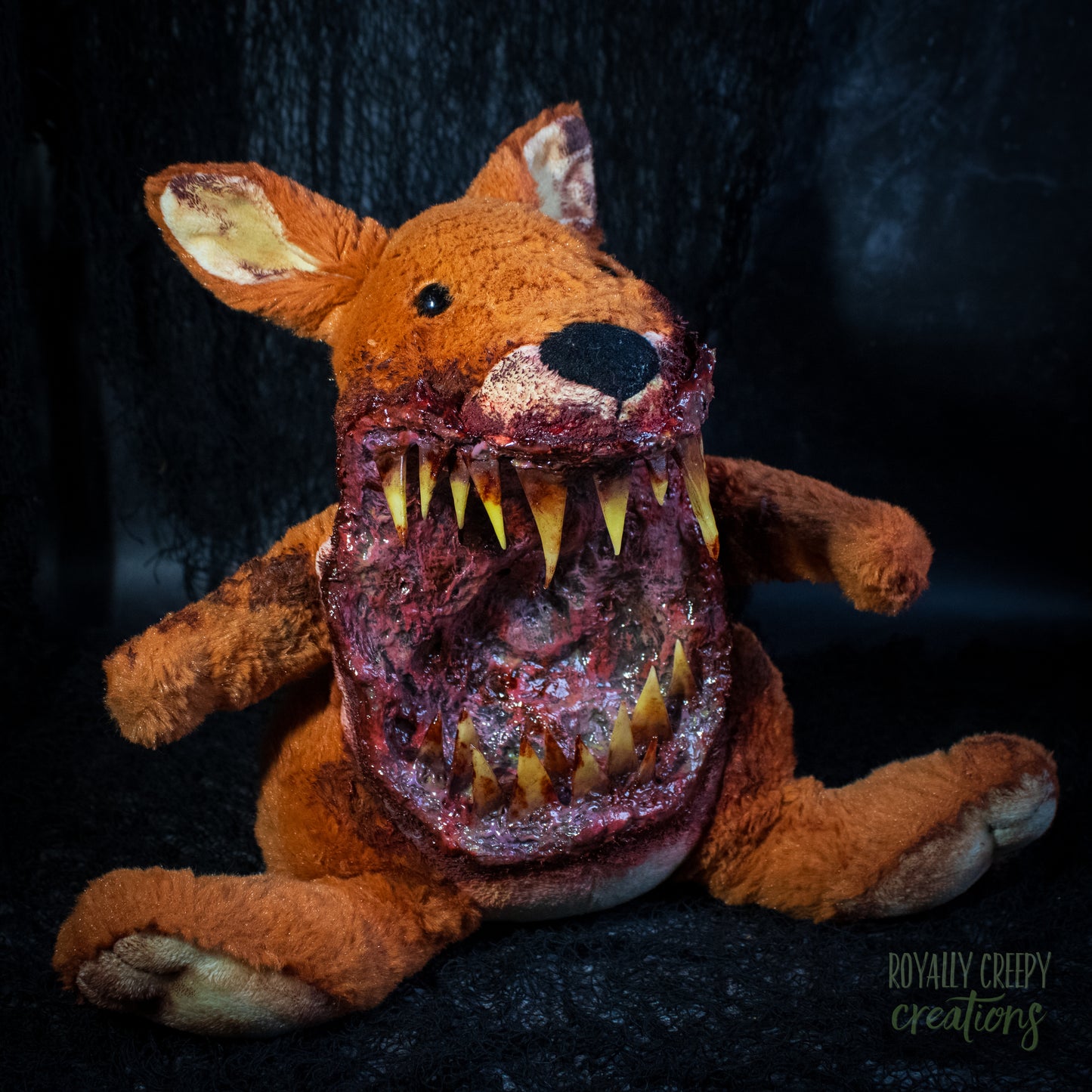 A horror-themed plush kangaroo toy with a grotesque, bloody open mouth showing sharp yellow teeth, posed against a dark textured background. A 'Royally Creepy Creations' watermark is visible in the bottom corner.
