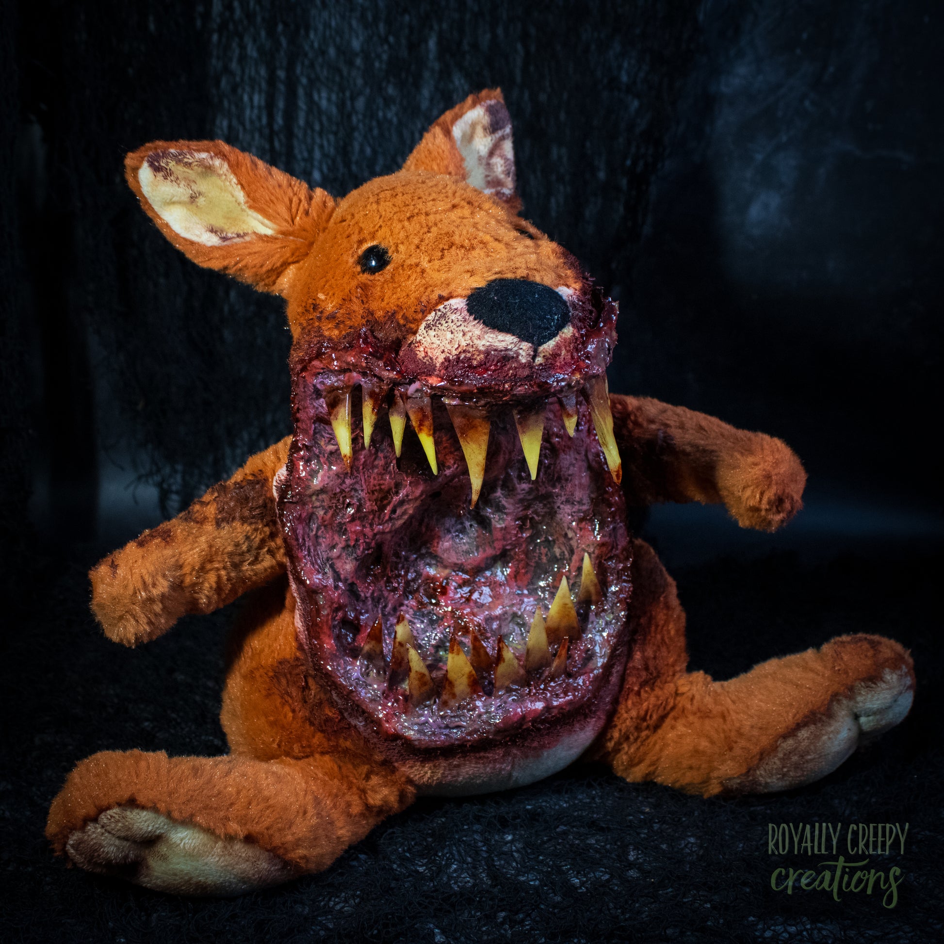 A horror-themed plush kangaroo toy with a grotesque, bloody open mouth showing sharp yellow teeth, posed against a dark textured background. A 'Royally Creepy Creations' watermark is visible in the bottom corner.