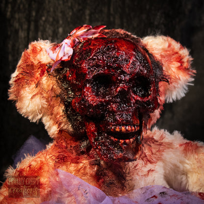 A horror-themed plush teddy bear with a bloody, skull-like face, blood-splattered fur, and a small pink bow on its head, set against a dark textured background.