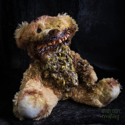 A horror-themed plush teddy bear with a grotesque, decayed mouth and exposed vomit set against a dark textured background. A 'Royally Creepy Creations' watermark is visible in the bottom corner.