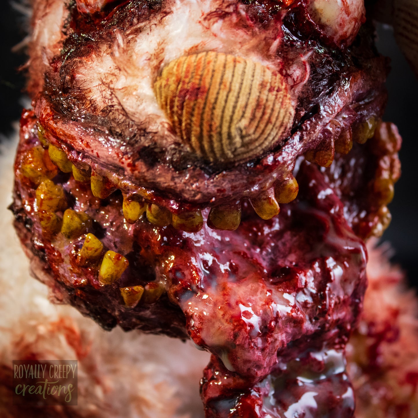 a close-up of a grotesque plush dog's mouth with yellow human teeth.