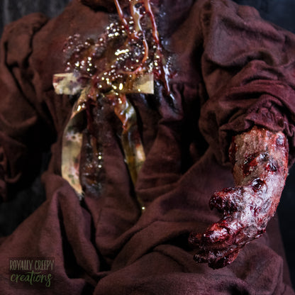 a close-up of a decayed bloody doll arm.
