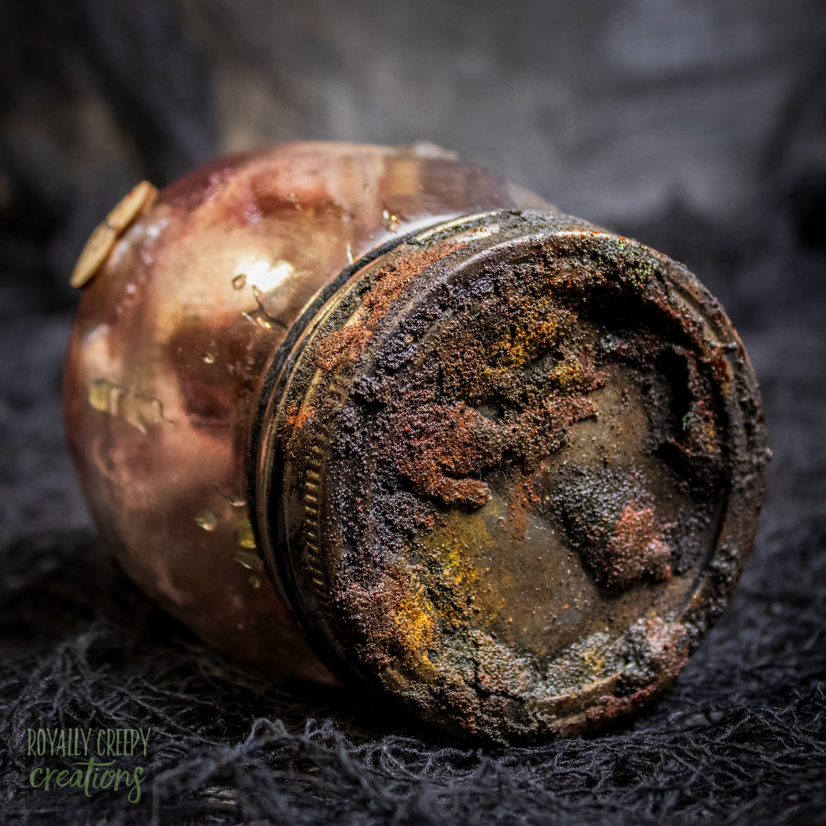 A creepy specimen prop of a rusted glass jar lid.