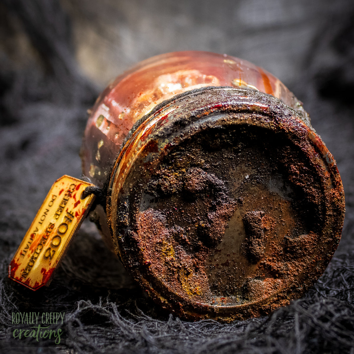 A close-up of a vintage-style glass jar with a rusty brown finish.