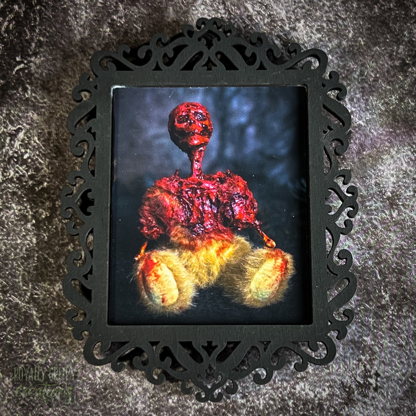 A gothic-style framed art print featuring a dark, eerie photograph of a grotesque teddy bear plushie.