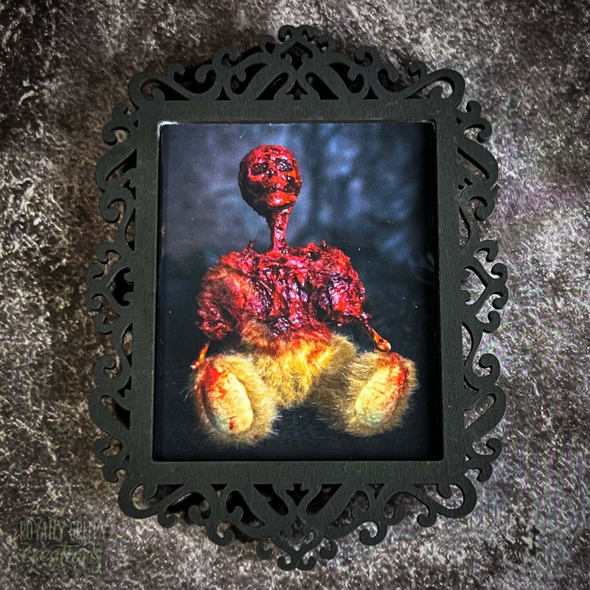 A gothic-style framed art print featuring a dark, eerie photograph of a grotesque teddy bear plushie.